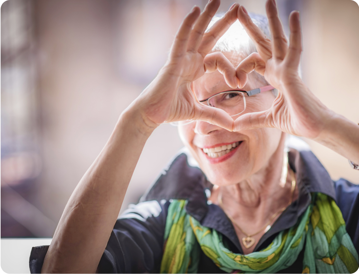personne agée fait un coeur avec c'est main